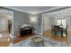 Elegant living area featuring hardwood floors, a piano, and an open layout to the dining room at 3284 Bakers Mill Ct, Dacula, GA 30019