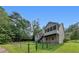 The back exterior of the house has a large fenced backyard and lots of beautiful green foliage at 3792 Refinement Way, Douglasville, GA 30135