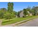 Exterior view of this house on a large lot with mature trees and a street sign at 3792 Refinement Way, Douglasville, GA 30135
