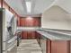 Modern kitchen features stainless steel appliances and wood cabinets at 3792 Refinement Way, Douglasville, GA 30135