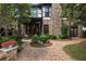 Beautiful backyard featuring a brick patio, stone accents, walkway, and lush landscaping around the perimeter at 625 Society St, Alpharetta, GA 30022