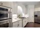 Elegant kitchen featuring stainless steel appliances, white cabinets, granite countertops, and dark hardwood floors at 625 Society St, Alpharetta, GA 30022