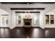 Cozy living room with dark wood floors, stone fireplace, wooden beams, and large windows with natural light at 625 Society St, Alpharetta, GA 30022