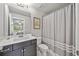 Well-lit bathroom featuring a modern vanity, sink, and shower with patterned curtain at 1094 Township Sq, Alpharetta, GA 30022