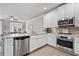 Bright, open kitchen with stainless appliances, white cabinets, granite counters and view to living area at 1094 Township Sq, Alpharetta, GA 30022
