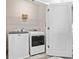 Convenient laundry room equipped with a washer, dryer, and shelving for storage at 1094 Township Sq, Alpharetta, GA 30022