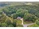 Aerial view of a property with lush landscaping surrounded by mature trees at 226 Nacoochee Dr, Woodstock, GA 30188