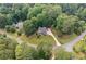 Aerial view of a home with lush landscaping and a long driveway surrounded by mature trees at 226 Nacoochee Dr, Woodstock, GA 30188