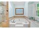 Bathroom featuring soaking tub, glass shower, and bright natural light at 226 Nacoochee Dr, Woodstock, GA 30188