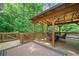 Inviting covered wood deck with outdoor seating provides a relaxing space surrounded by lush greenery at 226 Nacoochee Dr, Woodstock, GA 30188