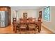 Traditional dining room features wood table and flooring, adjacent to the kitchen and stainless refrigerator at 226 Nacoochee Dr, Woodstock, GA 30188