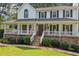 Charming home showcases a welcoming covered porch, complemented by stone accents and a well-maintained front lawn at 226 Nacoochee Dr, Woodstock, GA 30188