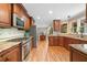 Spacious kitchen with stainless appliances, granite counters, and hardwood floors opens to dining area at 226 Nacoochee Dr, Woodstock, GA 30188