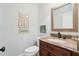 Cozy powder room featuring a vanity with a granite countertop, a sink, and a toilet at 226 Nacoochee Dr, Woodstock, GA 30188