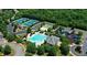 Stunning aerial view of community amenities featuring a pool, tennis courts, and playground surrounded by lush greenery at 306 Burdock Trce, Woodstock, GA 30188