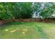 Lush green backyard with a mature lawn and wooden fence providing privacy and a serene outdoor space at 306 Burdock Trce, Woodstock, GA 30188