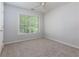This bedroom features neutral walls, a ceiling fan, and a window that lets in natural light at 306 Burdock Trce, Woodstock, GA 30188