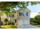 Charming two-story home featuring a well-maintained lawn and a two-car garage at 306 Burdock Trce, Woodstock, GA 30188