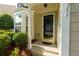 Close-up of the front door, featuring a glass pane, sidelights, and a well-manicured landscape at 306 Burdock Trce, Woodstock, GA 30188