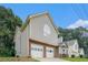 Side angle view of home showcasing garage, chimney, and siding against a backdrop of lush trees and a clear blue sky at 4400 Old Allgood Cir, Stone Mountain, GA 30083