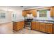 Efficient kitchen featuring stainless steel appliances, wood cabinets, and view to a dining area with natural light at 4400 Old Allgood Cir, Stone Mountain, GA 30083