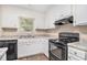 Well-lit kitchen features granite counters, black appliances, and white cabinetry at 5509 Park S Pl, Atlanta, GA 30349