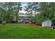 Expansive backyard featuring a patio, storage shed, and lush lawn at 1206 Red Fox Cir, Woodstock, GA 30188