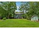 Large backyard with patio seating and a storage shed, surrounded by mature trees at 1206 Red Fox Cir, Woodstock, GA 30188