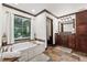 Bright bathroom with soaking tub, dark wood cabinets, and a large window at 1206 Red Fox Cir, Woodstock, GA 30188