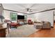 Spacious living room with ample seating, a ceiling fan, and plenty of natural light at 1206 Red Fox Cir, Woodstock, GA 30188