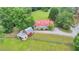 Aerial shot of a property with a bright red roof, large trees, and outbuildings at 1365 Lower Creighton Rd, Cumming, GA 30028