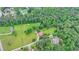 Aerial view of acreage featuring a farmhouse, barn, and large yard in a forested area with mature trees at 1365 Lower Creighton Rd, Cumming, GA 30028