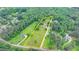 Aerial view of property with land outline featuring a farmhouse, barn, and ample green space surrounded by trees at 1365 Lower Creighton Rd, Cumming, GA 30028