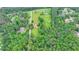 Aerial view of countryside featuring a farmhouse, barn, open fields, and surrounding lush green forest at 1365 Lower Creighton Rd, Cumming, GA 30028