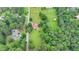 Aerial view of land featuring a farmhouse, barn, expansive yard, and bordered by mature green trees at 1365 Lower Creighton Rd, Cumming, GA 30028