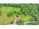 Aerial view of land featuring a farmhouse, barn, large open yard and bordering mature green trees at 1365 Lower Creighton Rd, Cumming, GA 30028