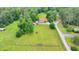 Aerial view of the home, barn, pasture, and surrounding trees provides privacy and space at 1365 Lower Creighton Rd, Cumming, GA 30028