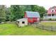 A classic red barn with a silver metal roof, perfect for storage or livestock at 1365 Lower Creighton Rd, Cumming, GA 30028