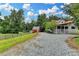 Charming country home with a red roof, white siding, a barn, and a long gravel driveway at 1365 Lower Creighton Rd, Cumming, GA 30028