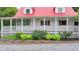 Eye-level of porch with white railings, and foundation landscaping under a red roof with dormer windows at 1365 Lower Creighton Rd, Cumming, GA 30028