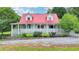 Inviting home with a red roof, dormer windows, a spacious wrap-around porch, and landscaped front at 1365 Lower Creighton Rd, Cumming, GA 30028