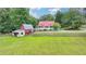 An expansive country home features a barn, pastures, and a long front porch at 1365 Lower Creighton Rd, Cumming, GA 30028