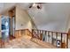 Hallway with wood floors and staircase overlooking a tiled bathroom and leading to another bedroom at 1365 Lower Creighton Rd, Cumming, GA 30028