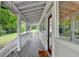 View of covered porch with gray decking and white railing overlooking the property at 1365 Lower Creighton Rd, Cumming, GA 30028