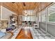 Light-filled sunroom featuring wood ceilings, stone details and large windows at 1365 Lower Creighton Rd, Cumming, GA 30028
