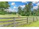 Expansive, fenced-in yard with mature trees and a red shed under a blue sky at 1365 Lower Creighton Rd, Cumming, GA 30028