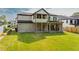 Expansive backyard view of a two-story home with a covered patio and well-maintained lawn at 157 Shadburn Ferry Rd, Buford, GA 30518