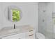 Stylish bathroom with modern vanity, round mirror, and glass-enclosed shower at 157 Shadburn Ferry Rd, Buford, GA 30518