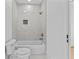 Bathroom with a white tiled shower/tub featuring gold fixtures and a matching toilet at 157 Shadburn Ferry Rd, Buford, GA 30518