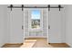 Sunlit bedroom with sliding barn doors and built-in shelving showcasing a bright and spacious interior at 157 Shadburn Ferry Rd, Buford, GA 30518